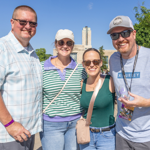 Two couples attending an event with the Hall of Waters in the background