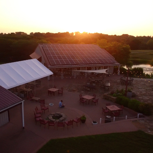 Fence Stile Winery outdoor patio with seating, string lights, and sunset view in Missouri wine country