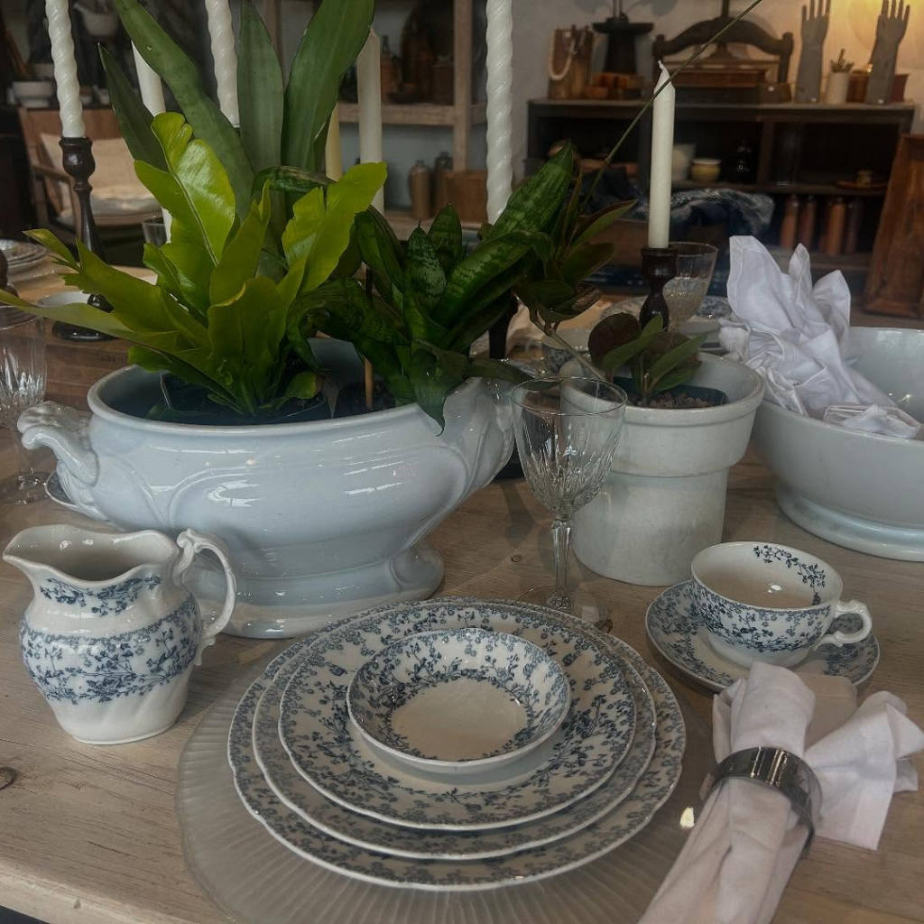 Elegant table setting with vintage-style dishware, candles, and greenery inside Kilgore’s 414 Company home decor shop.