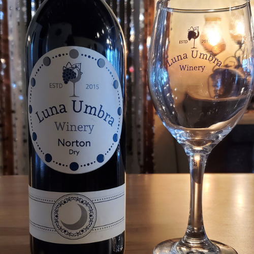 Luna Umbra Winery Norton dry red wine bottle and branded glass on a tasting bar