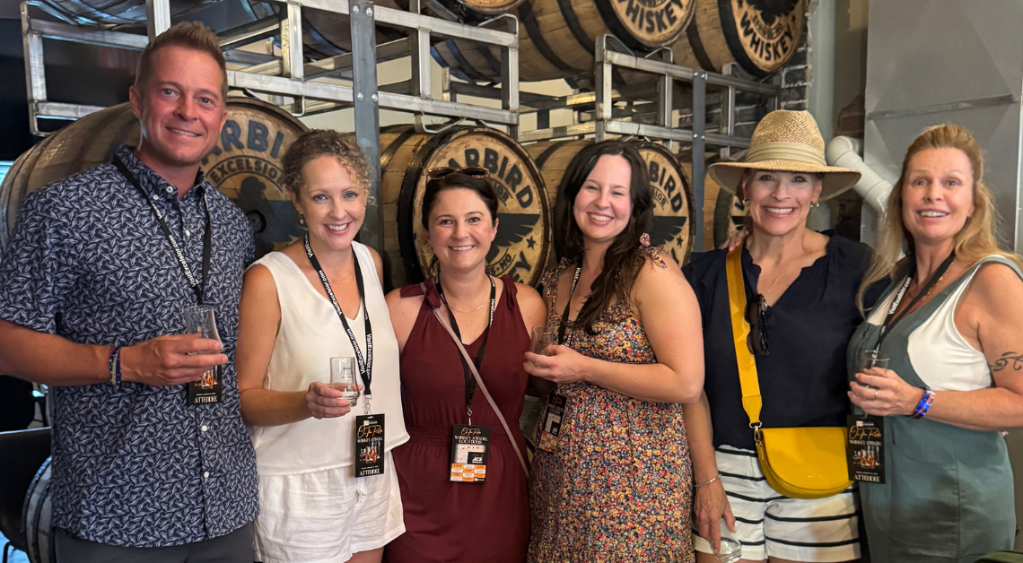 A group of six people attending On The Rocks Whiskey Stroll in Downtown Excelsior Springs inside Warbird Whiskey.