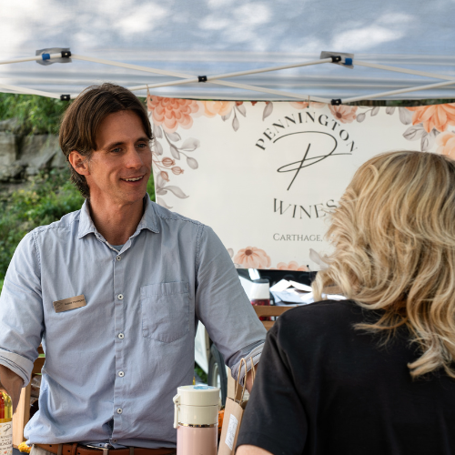 Pennington Wines vendor serving customers at an outdoor wine festival booth in Missouri