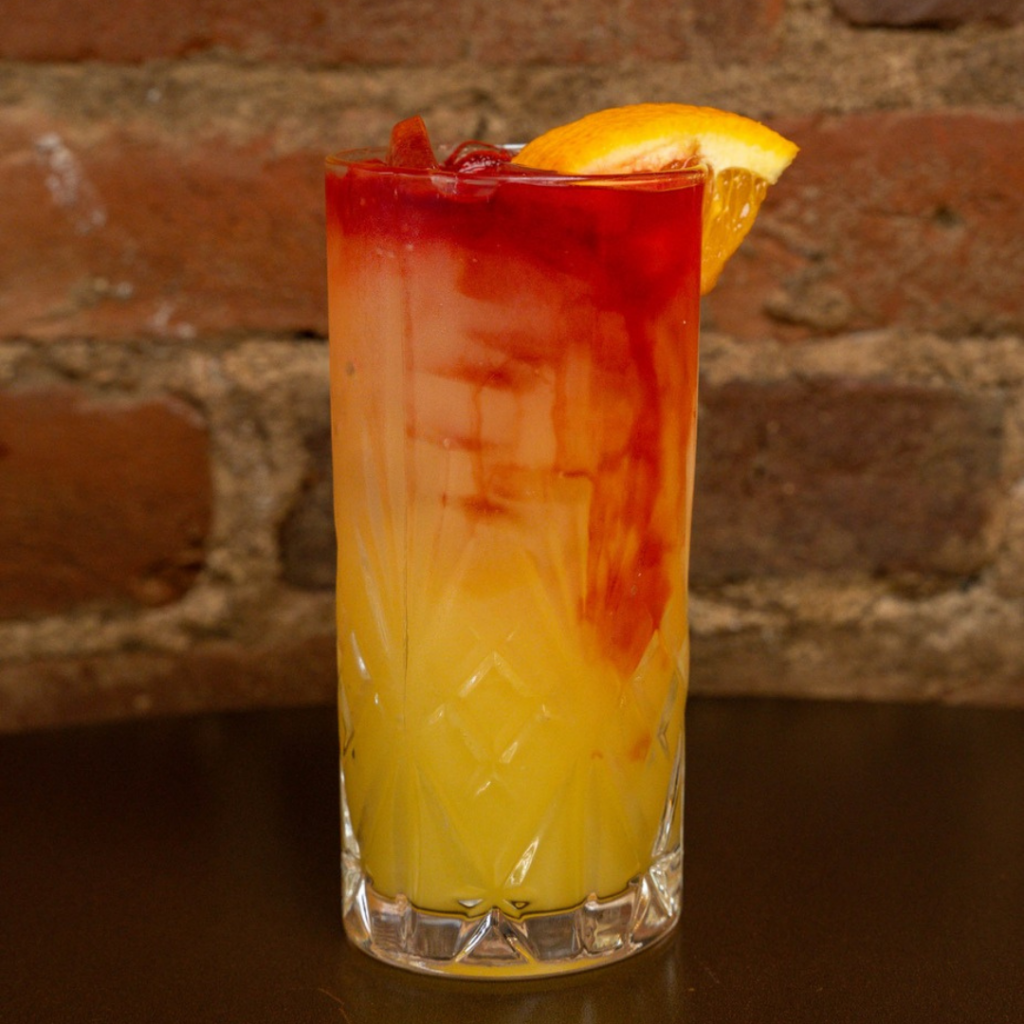 Layered orange and red cocktail with citrus garnish served at Ventana Gourmet Grill in downtown Excelsior Springs.