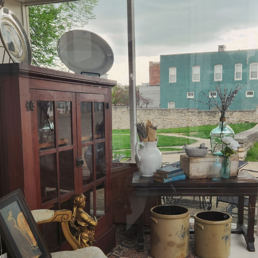 Vintage furniture and home décor display with ceramics and wood accents inside Vesta Hearth & Home in downtown Excelsior Springs.