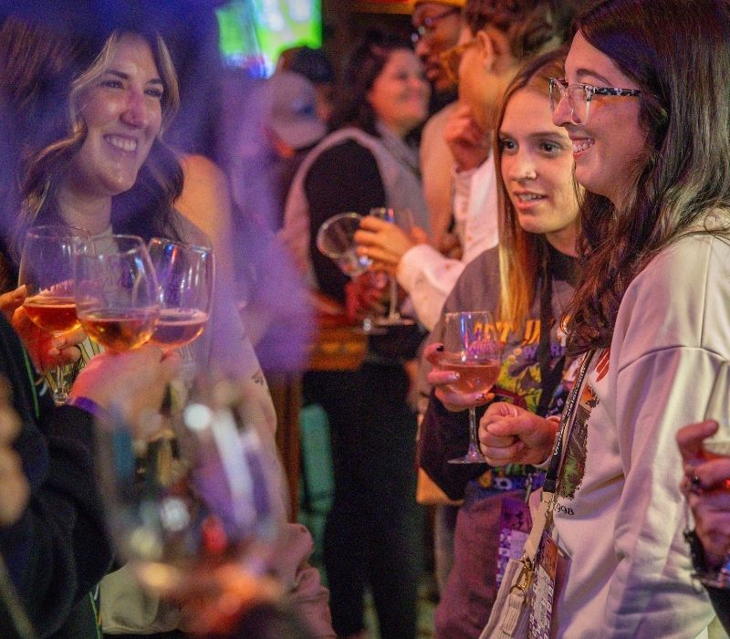 Attendees enjoy wine samples together at a participating downtown location.