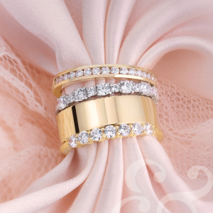 White gold ring featuring a blue heart-shaped gemstone and a pear-shaped diamond with additional diamonds along the band, displayed in a gray jewelry box.