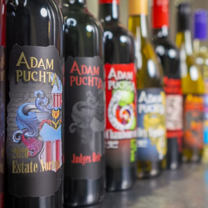 Adam Puchta Winery bottles including Estate Norton and Judge’s Red displayed at a tasting counter in Excelsior Springs, Missouri.