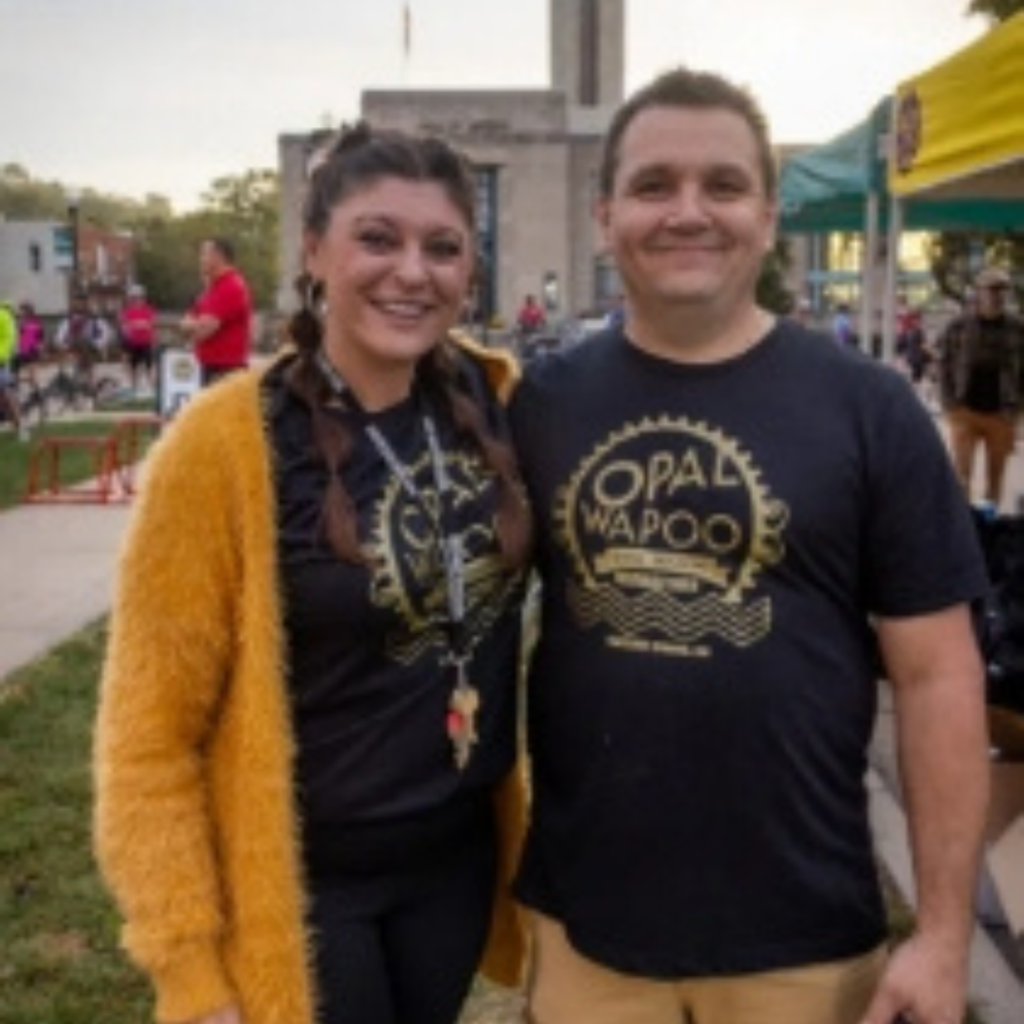 Organizers of the Opal Wapoo Gravel Experience pose together before the event, celebrating community partnerships that bring cyclists to Excelsior Springs.