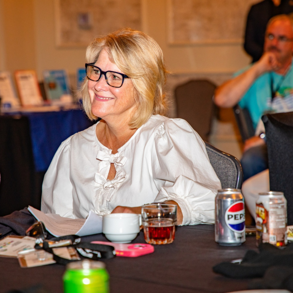An attendee listens during a conference session focused on entrepreneurship, downtown revitalization, and community development strategies.