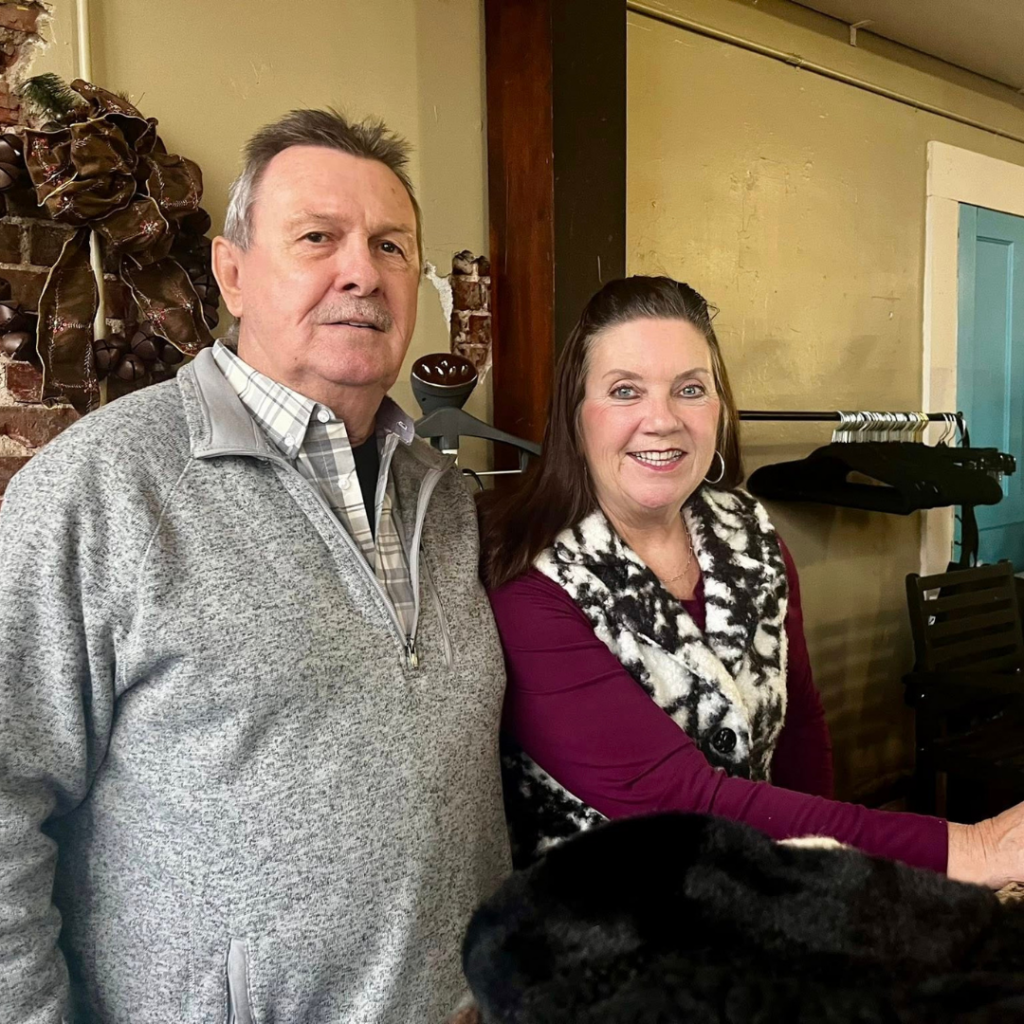 Carol Baxter and her husband stand inside Butterfly Kisses Boutique, the downtown Excelsior Springs business she opened after years of supporting local revitalization efforts.