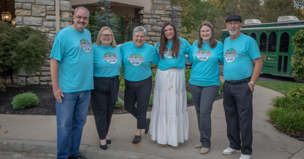 Members of the Excelsior Springs planning team gather outside The Elms Hotel & Spa while hosting the Connecting Entrepreneurial Communities Conference, showcasing collaboration between local organizations and community leaders.