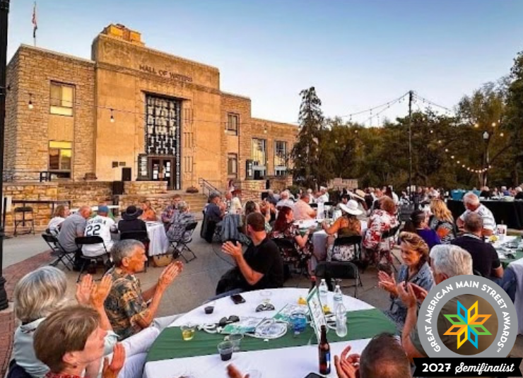 Guests applaud at outdoor dinner tables in front of the Hall of Waters.