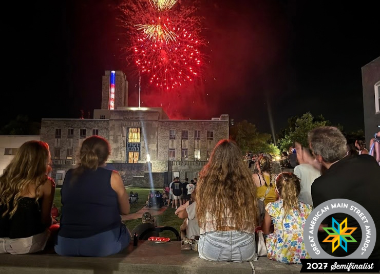 People watch red fireworks above the Hall of Waters in downtown Excelsior Springs.