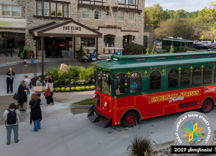 The Excelsior Springs trolley stops outside The Elms Hotel as visitors walk nearby.